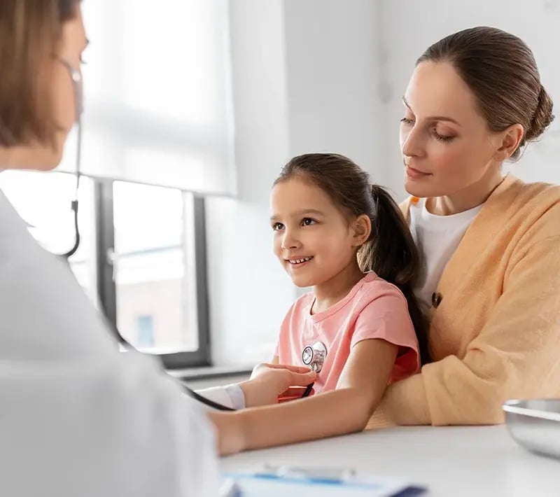 Child gets a heart checkup with a parent nearby.