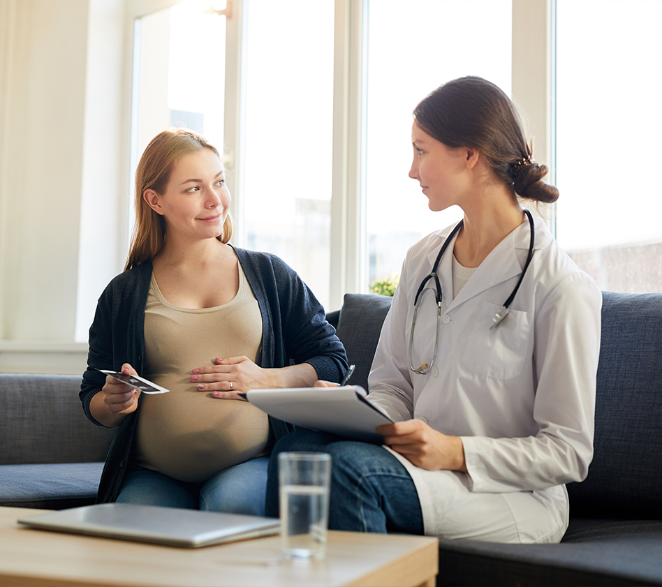 Pregnant woman talking with a healthcare provider during a prenatal visit.