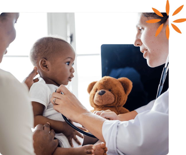 Pediatrician examines a baby while a parent holds them during a checkup.