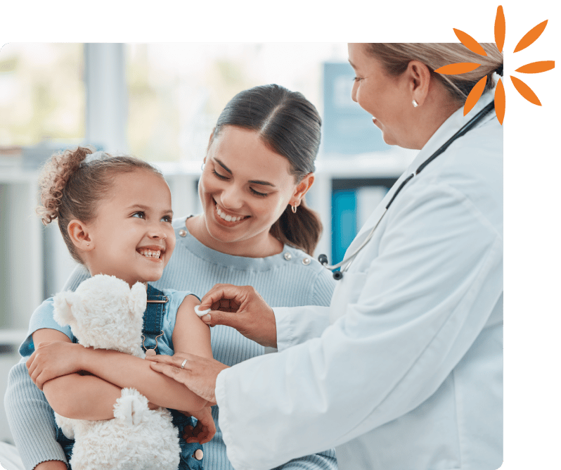 Pediatrician gives a smiling child a vaccine while a parent looks on.